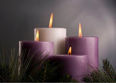 Photo of 4 lit Advent pillar candles and small fir branches