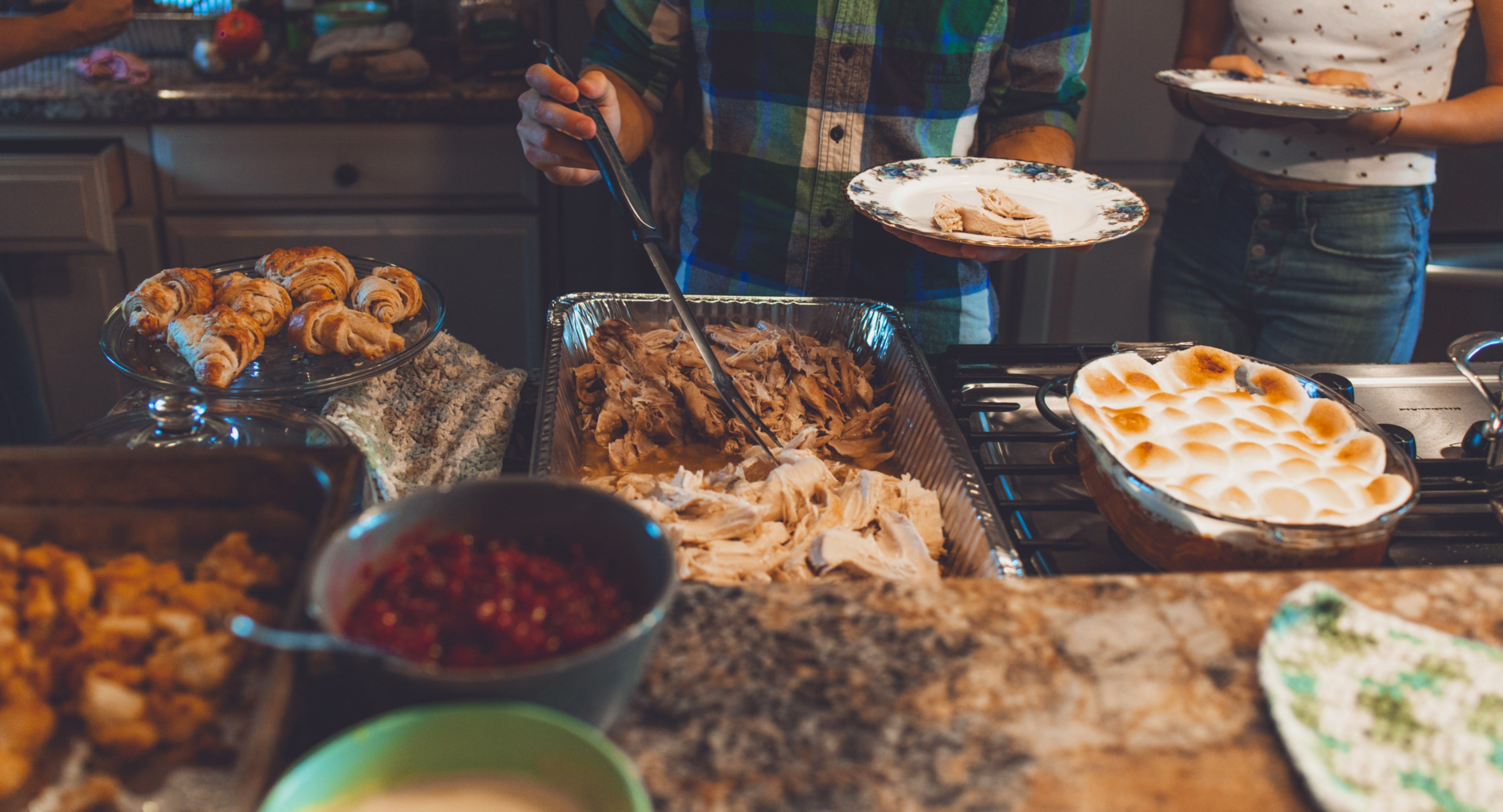 Photo of people getting food at a Potluck dinner