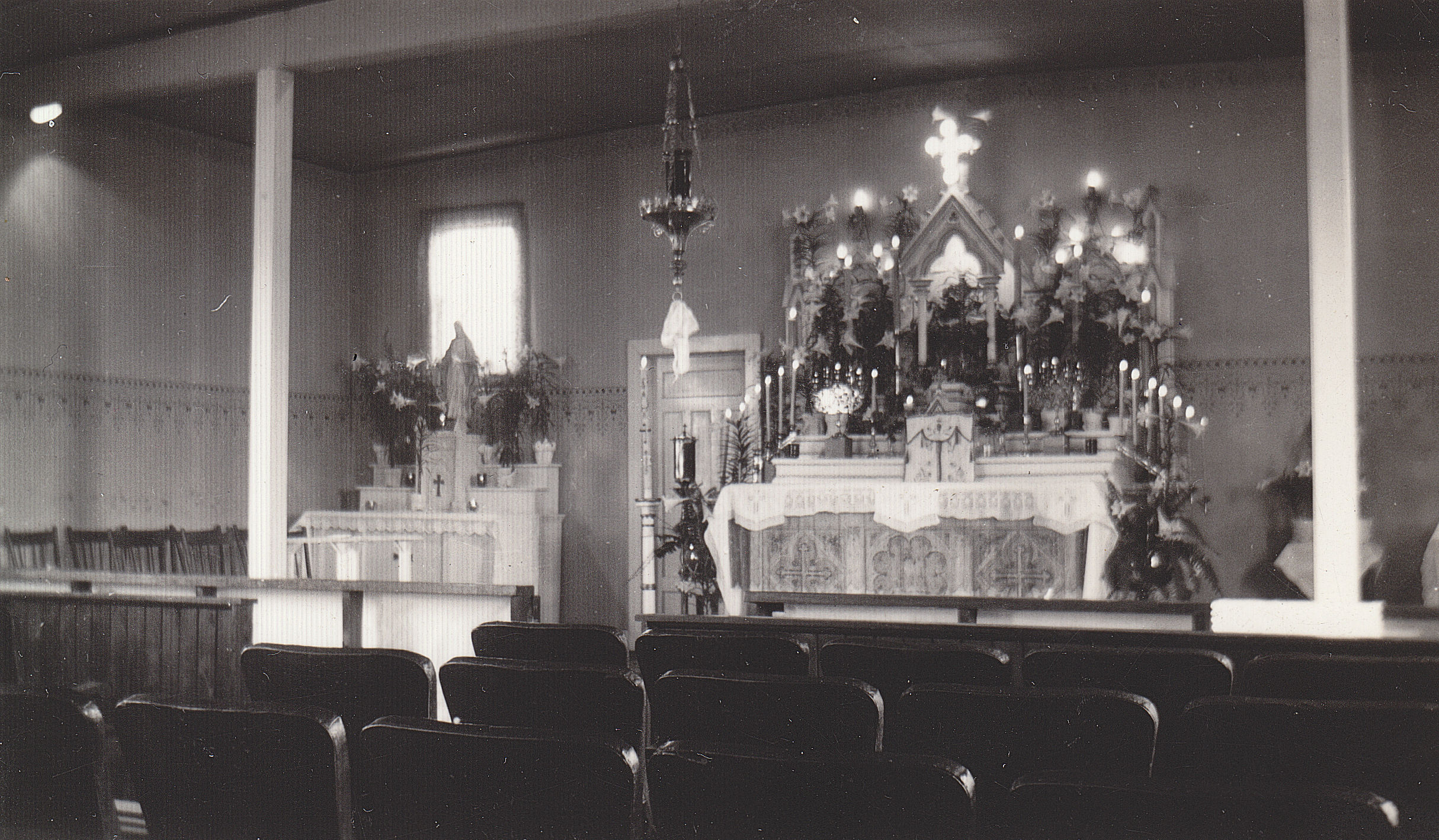 Photo showing the interior of the original church with its main altar and theatre seats
