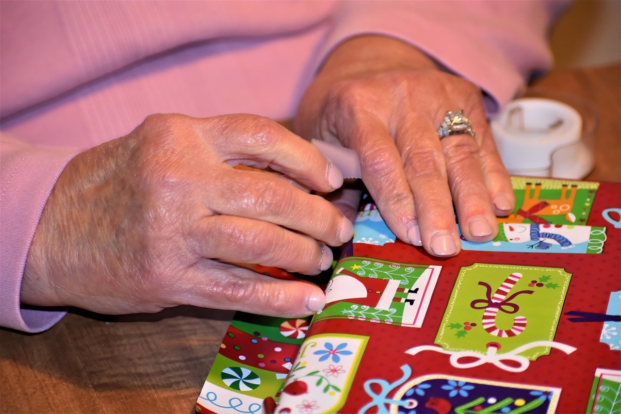 Photo showing hands wrapping a Christmas gift