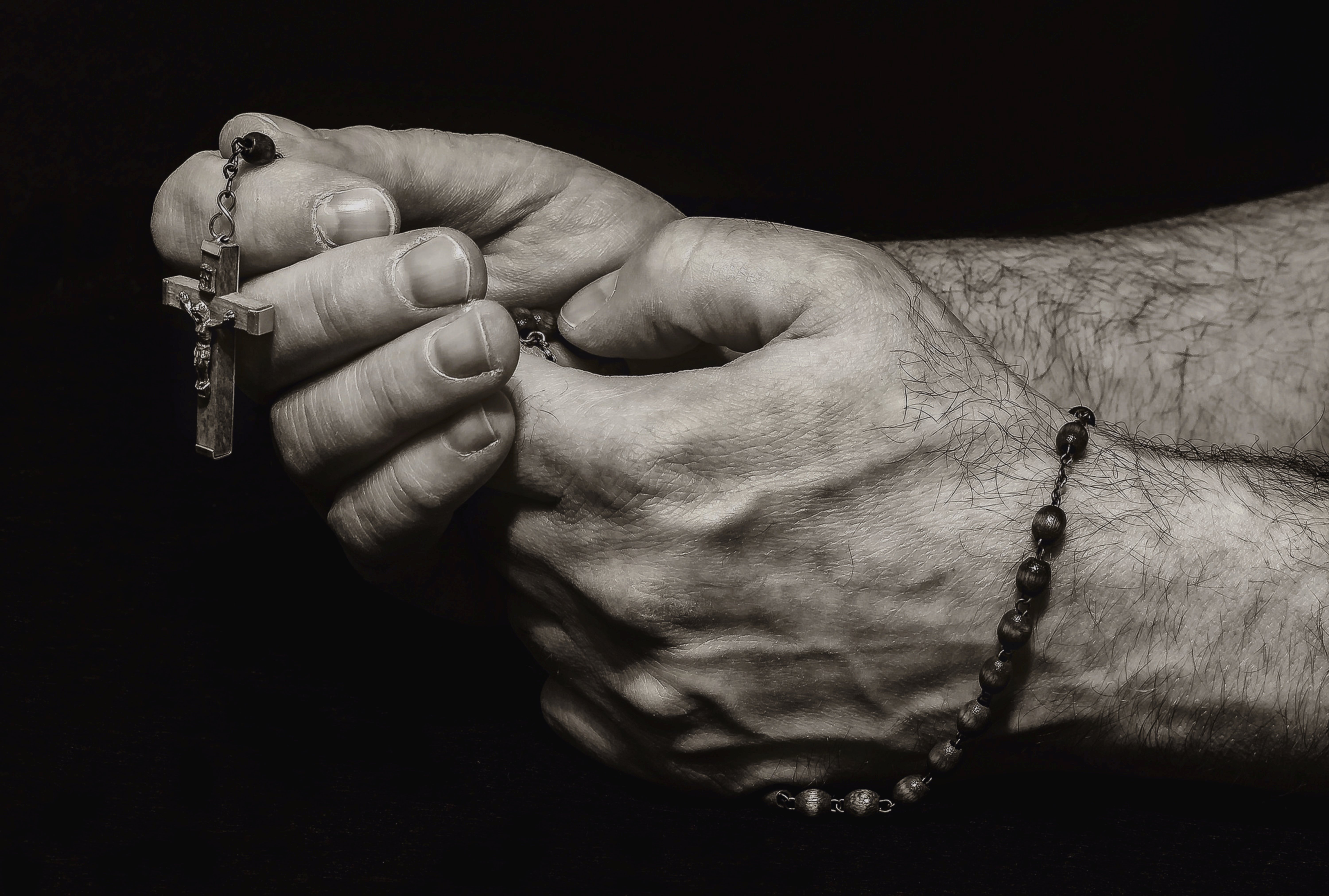 photo of folded hands with rosary