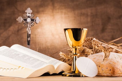 Photo of an altar with the wine, chalice, bread and open book of prayers