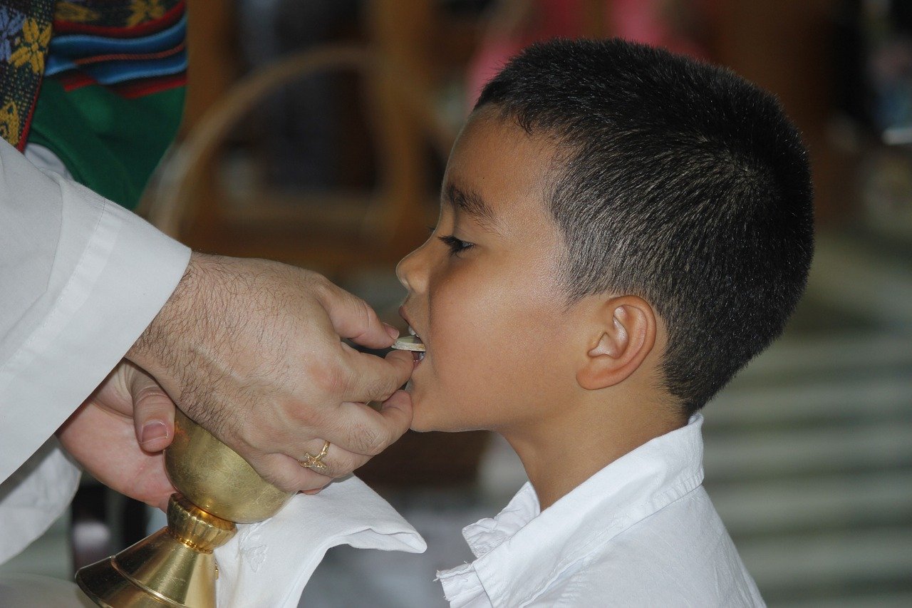 Photo of a young boy receiving first Communion